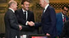 US-Präsident Joe Biden (r) und Frankreichs Präsident Emmanuel Macron begrüßen sich während des G20-Gipfels in Indonesien, daneben steht Bundeskanzler Olaf Scholz (SPD, l).