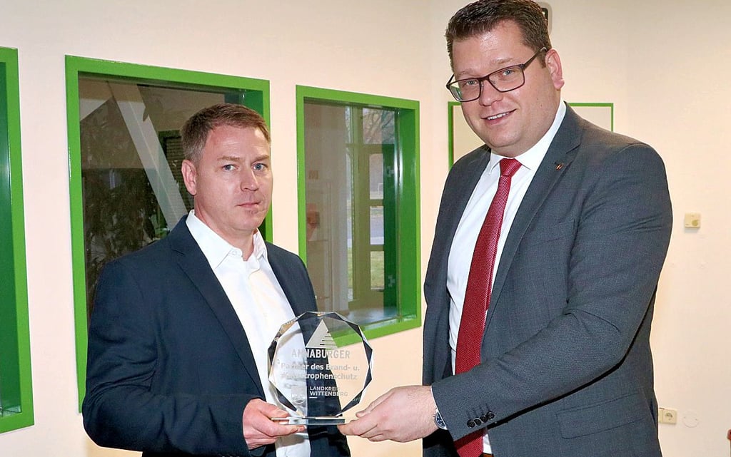 Landrat Christian Tylsch (rechts) ehrt die Annaburger Nutzfahrzeug GmbH als Partner des Brand- und Katastrophenschutzes und überreicht an Geschäftsführer André Lüderitz die Auszeichnung.