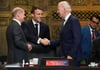 US-Präsident Joe Biden (r) und Frankreichs Präsident Emmanuel Macron begrüßen sich während des G20-Gipfels in Indonesien, daneben steht Bundeskanzler Olaf Scholz.