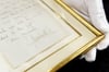 Ein Brief von Königin Elizabeth II. ist für 8300 Euro versteigert worden. Die Unterschrift der Queen ist auf einer Kopie der Rückseite zu sehen, welche dem eingerahmten Brief beiliegt.