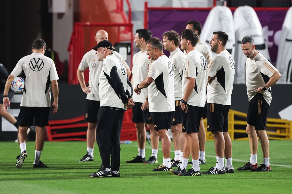 Das deutsche Trainer- und Betreuerteam steht mit Bundestrainer Hansi Flick (M) beisammen.