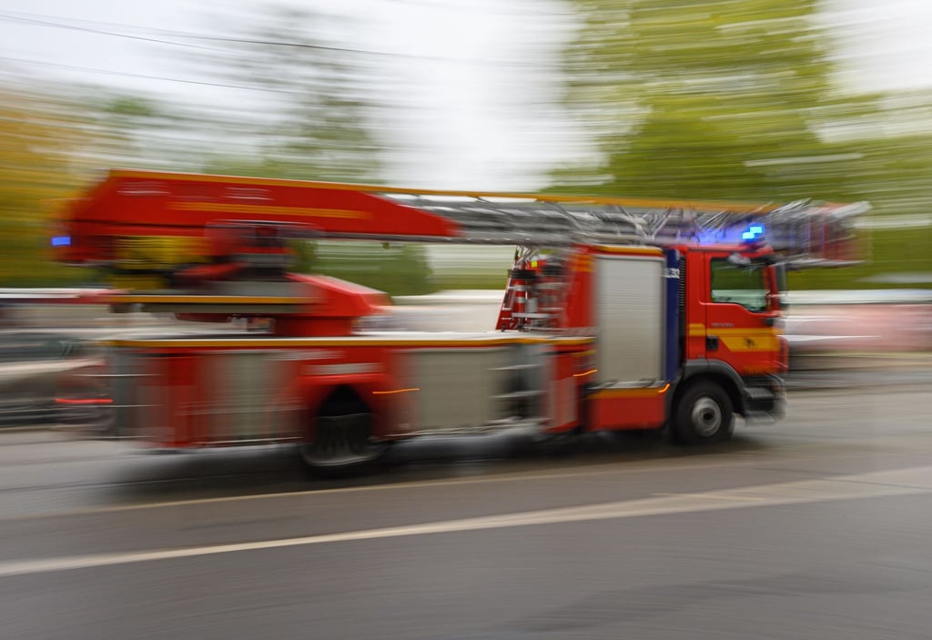 Ein Feuerwehrfahrzeug mit Drehleiter fährt zu einem Einsatz.