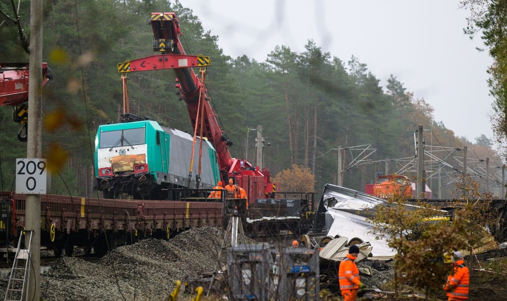 Eine verunfallte Lok wird mit einem Kran auf einen Waggon gehoben.
