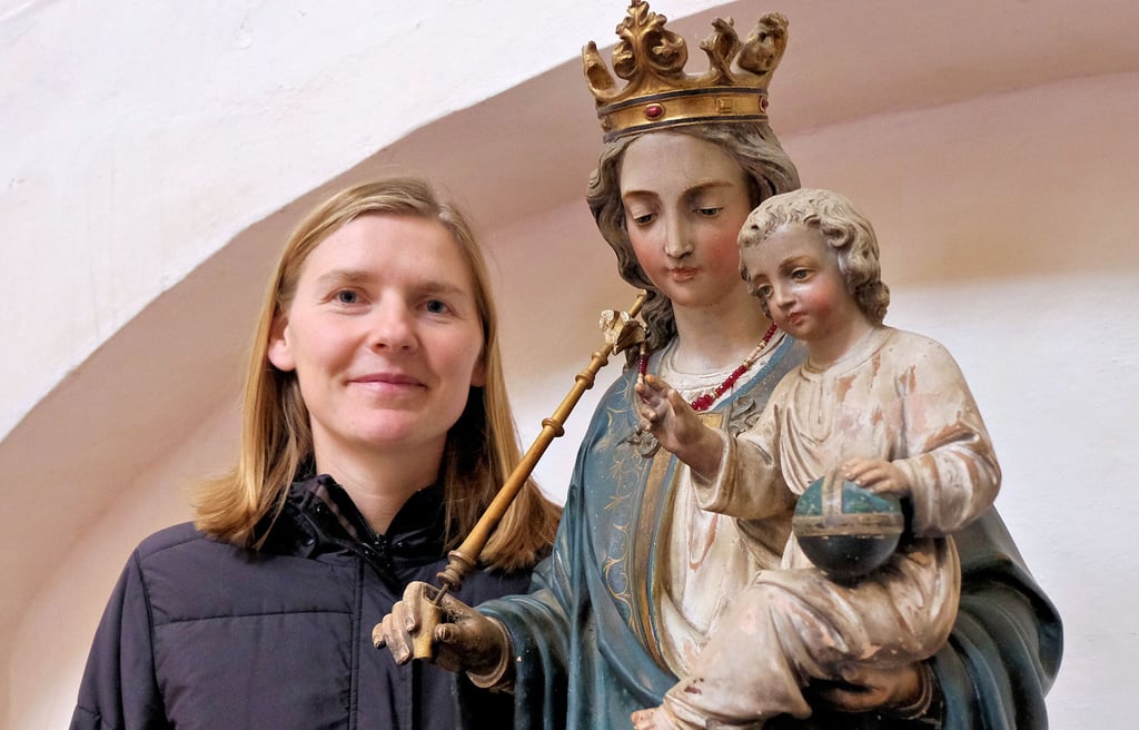 Pfarrerin Judith Kölling, hier neben der Statue von Maria mit dem Jesuskind in der Zahnaer Kirche, freut sich auf das Weihnachtsfest.
