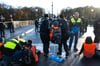 Polizisten tragen in München einen Klimaaktivisten der „Letzten Generation“ weg, der sich zuvor auf der Prinzregentenstraße auf den Asphalt geklebt hatte.