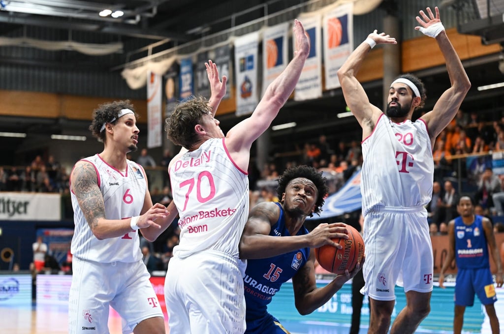 Weißenfels Stephon Jelks (2.v.r.) wird von Bonns Jeremy Morgan (r) und Finn Delany behindert.