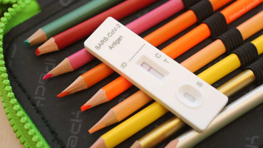 Ein Kit für einen Corona-Schnelltest liegt auf dem Federmäppchen eines Schülers.