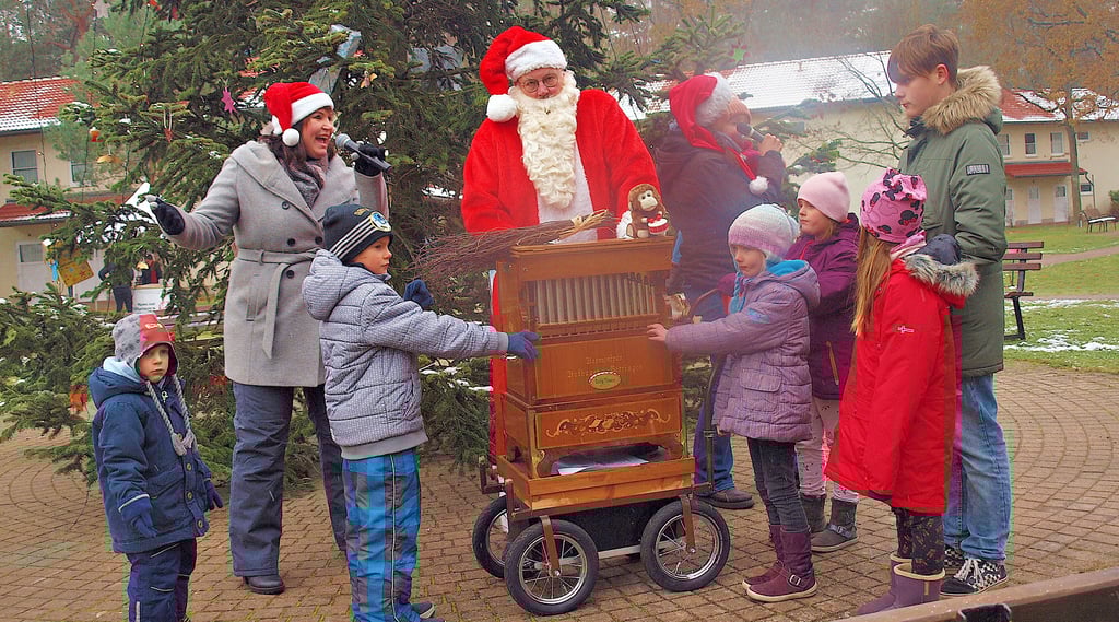 Die Kinder bestaunten die Drehorgel, mit der der Weihnachtsmann von der Hamburger Muscialbühne am Christbaum im Integrationsdorf Arendsee für Advcentsklänge sorgte. Dabei unterstütze ihn das Gesangsduo Xandra Dee und Hannah David.
