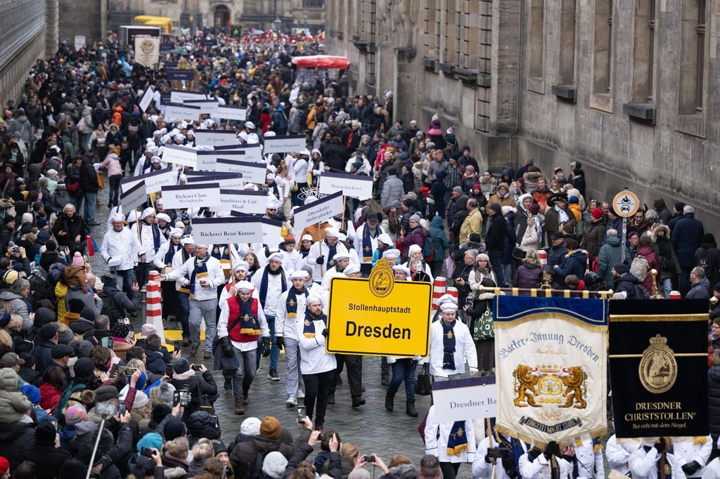 Teilnehmer des Festumzug zum Dresdner Stollenfest gehen am Fürstenzug entlang.