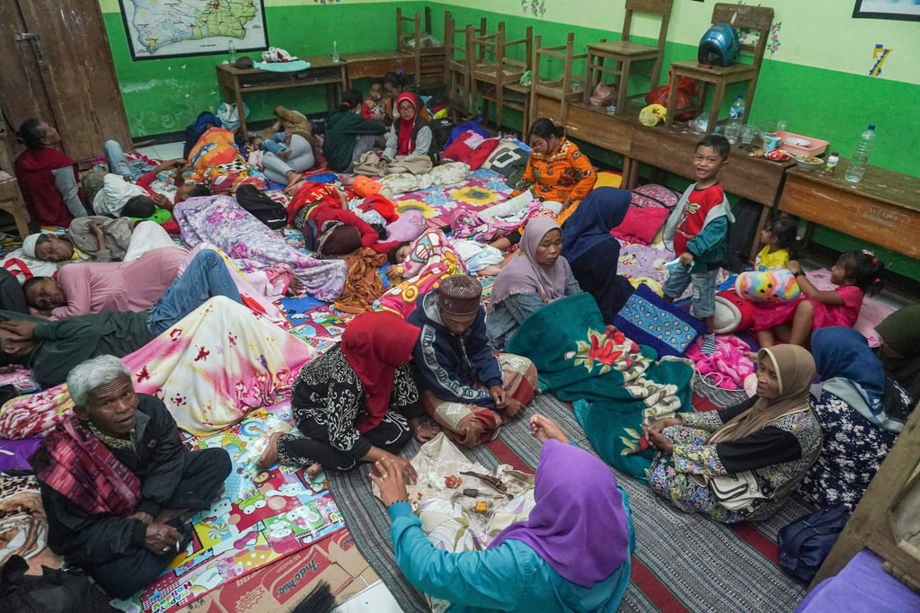 Menschen suchen in einer Schule Schutz, die nach dem Ausbruch des Vulkans Semeru als vorübergehende Unterkunft für die aus ihren Häusern Evakuierten dient.