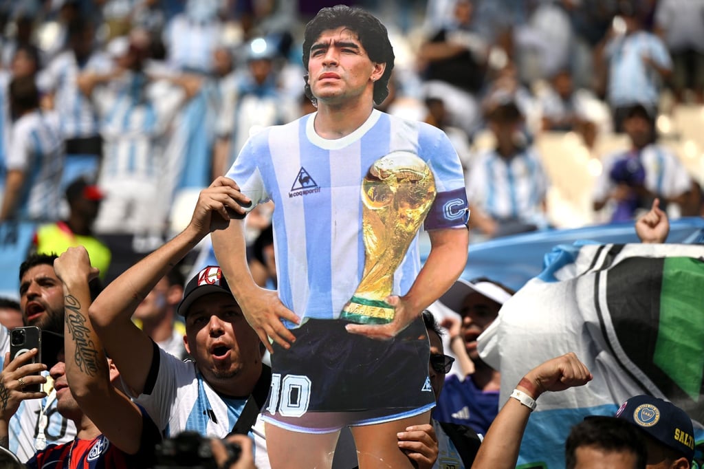 Fans feiern vor Spielbeginn mit einem Poster des ehemaligen Argentinischen Fussballspielers Diego Maradona.
