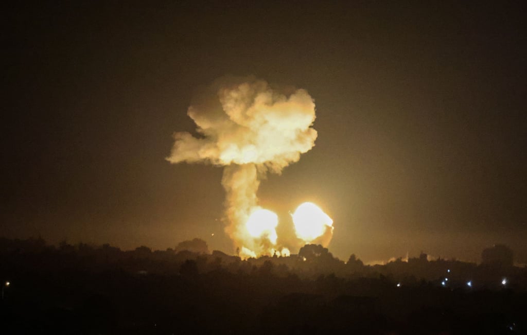 Ein Feuerball und eine Rauchwolke steigen während eines Luftangriffs über Gebäuden auf.