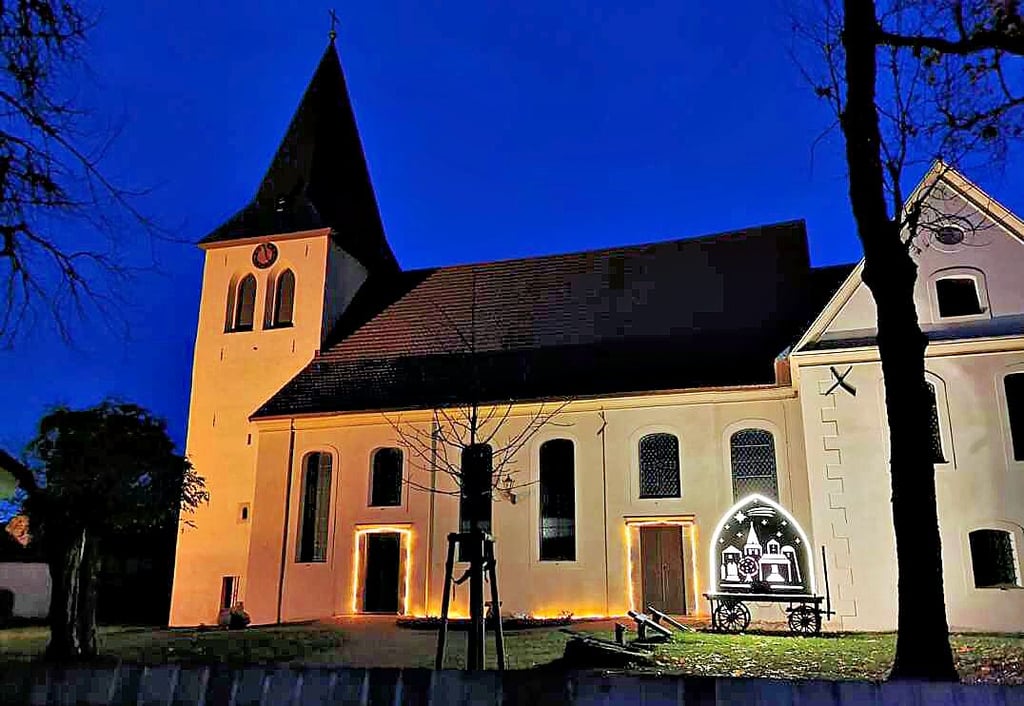 Ein stimmungsvolles Bild: Der beleuchtete Schwibbogen steht am Haupteingang der Rosenburger Kirche. Die Geschichte des Wagens, auf dem der Schwibbogen steht, ist durchaus ungewöhnlich.