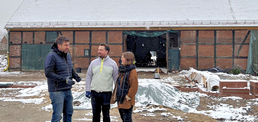 Marco Radke im Gespräch mit Carl und Eve Heine vor der großen Eventscheune in Weißewarte. Sie gehört zum historischen Forsthof, dem wohl ältesten Bauwerk im Dorf.