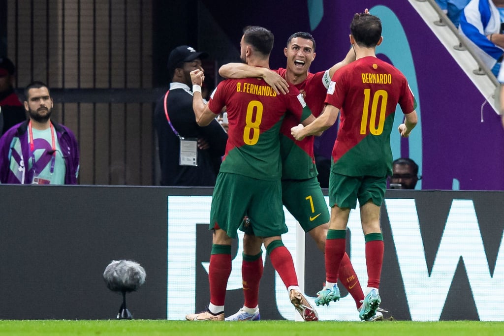 Portugals Bruno Fernandes (l) jubelt nach seinem Tor zum 1:0 gegen Uruguay mit Cristiano Ronaldo (M) und Bernardo Silva (r).