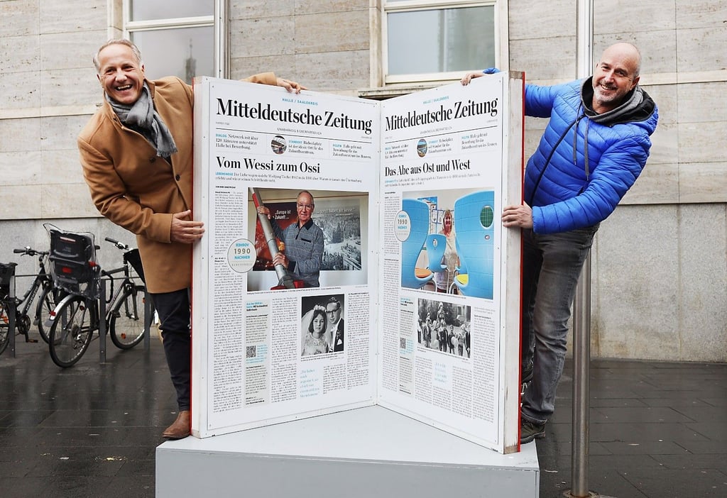 Stadtmarketing-Chef Mark Lange (links) und Dirk Skrzypczak, Chefreporter der MZ in Halle, an einem der XXL-Bücher vor dem Ratshof