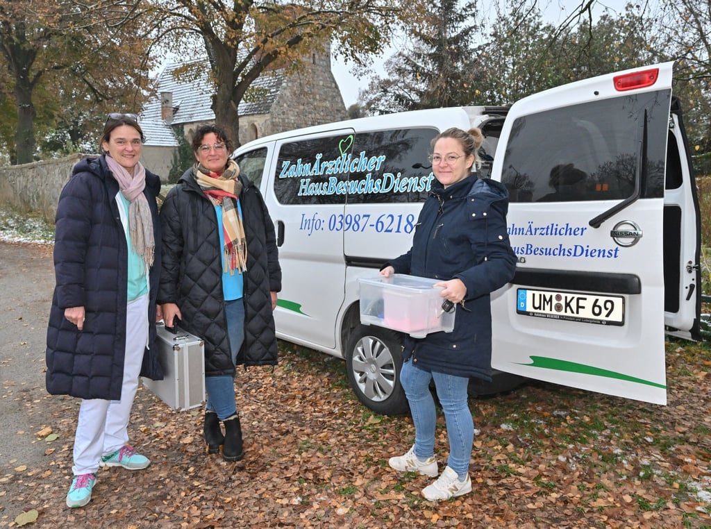 Kerstin Finger (l), Zahnärztin, sowie die beiden Zahnmedizinischen Fachangestellten stehen vor ihrem Fahrzeug.