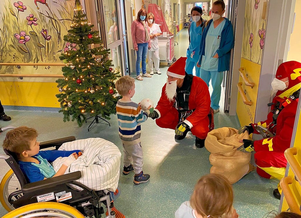 Verkleidet als Nikolaus und Superheld Flash bringen Höhenretter der Magdeburger Feuerwehr kleine Spielzeuge und Schokolade auf die Kinderstation im Klinikum Olvenstedt.