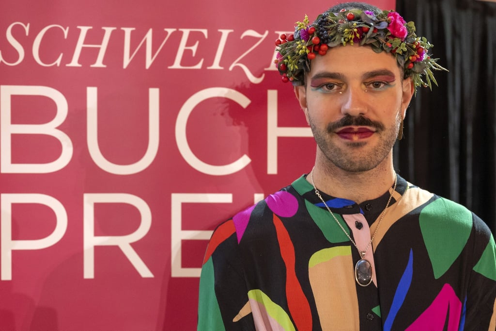 Kim de l'Horizon posiert nach der Preisverleihung zum Schweizer Buchpreis 2022 für ein Foto.