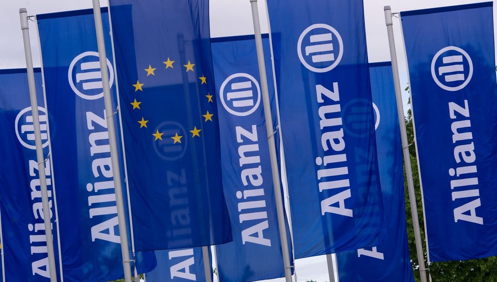 Fahnen des Versicherungskonzerns Allianz wehen vor der Olympiahalle in München.