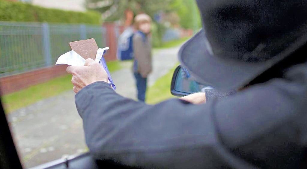 Auf diesem gestellten Foto lockt ein Mann ein Kind mit Schokolade ins Auto. In Zeitz sollen jetzt Tierkinder Lockmittel gewesen sein.