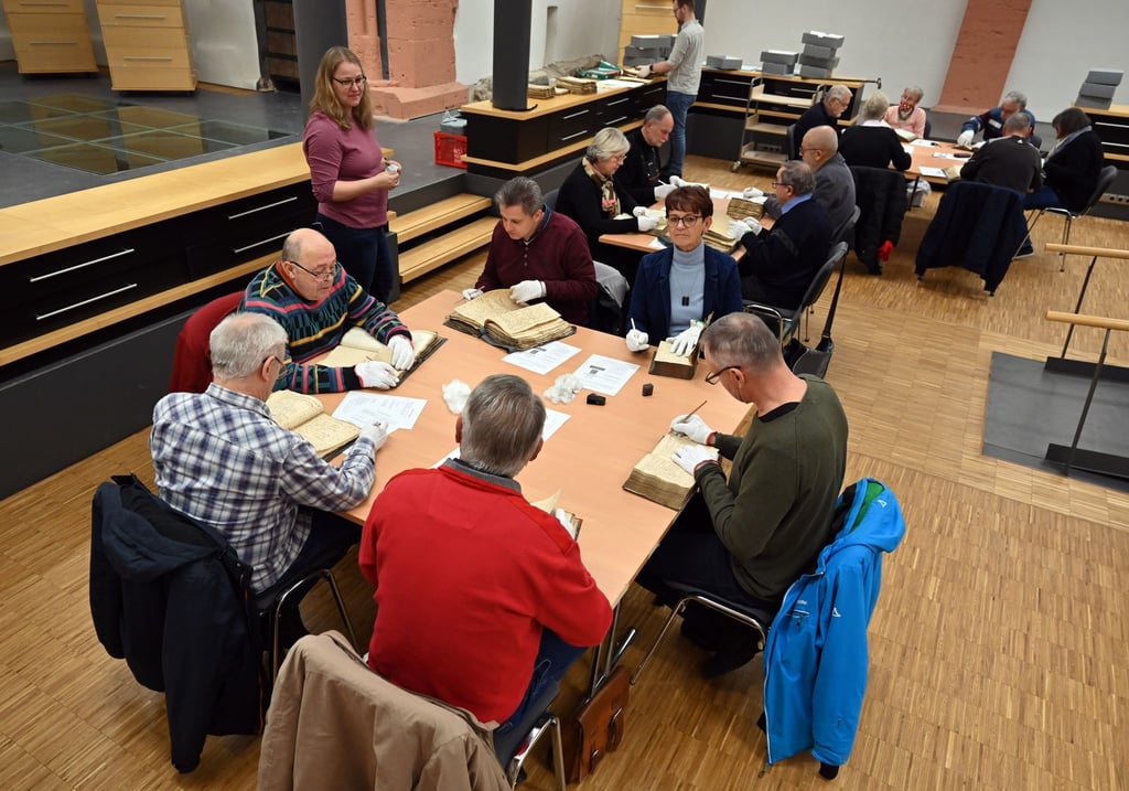Beteiligte einer Gemeinschaftsaktion zur Sicherung der wertvollen Akten der Stadt Mühlhausen arbeiten in der Stadtbibliothek Jakobikirche zusammen.