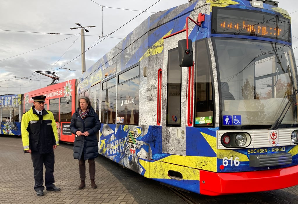 Nachwuchs gesucht: Innenministerin Tamara Zieschang und Andreas Dockhorn, kommissarischer Leiter des Polizeireviers Halle, vor der Straßenbahn mit Polizei-Werbung