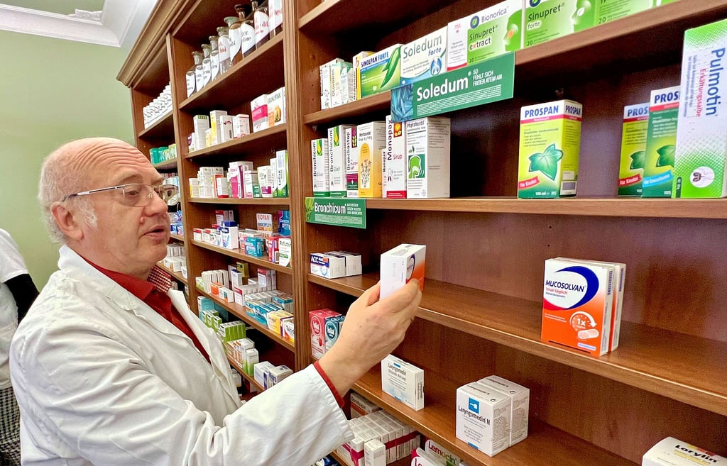 Apotheker Henrik Frenzel von der Grünen Apotheke in Bernburg schaut in das leere Regal.