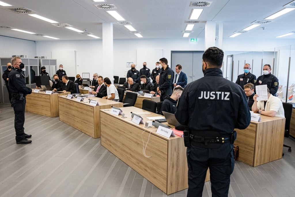 Die Angeklagten sitzen im Oberlandesgericht Dresden neben ihren Anwälten.