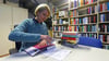 Bibliotheksleiterin Susanne van Treek stempelt ein neues Buch als Eigentum der Kreisbibliothek Aschersleben.