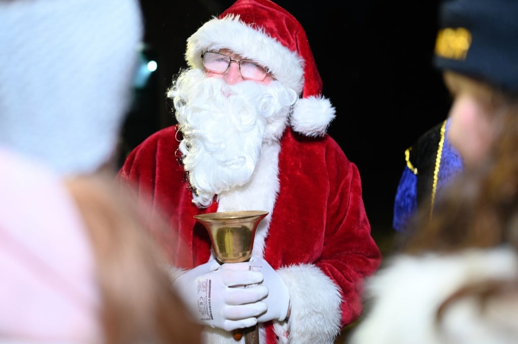 Der Nikolaus beschenkt Kinder.