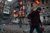 Ein Anwohner verlässt in Bachmut sein Wohnhaus, das nach einem Beschuss in Flammen steht.