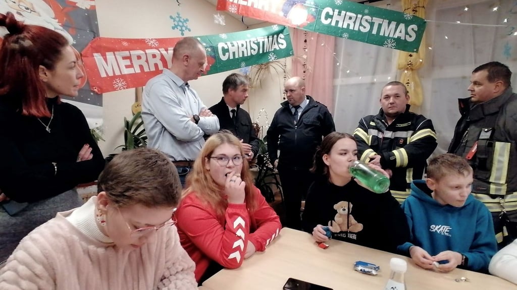 Ronald Gattermann und Steffen Amme im Gespräch mit Stadtjugendfeuerwehrwart Marcus Brune (hintere Reihe, 2. bis 4. v. l.).