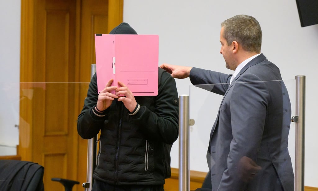 Der Angeklagte wird von seinem Anwalt in den Saal des Landgerichtes geführt.