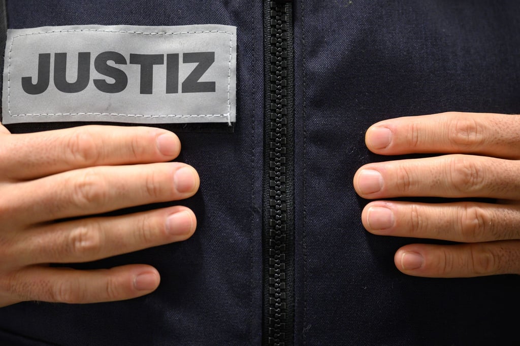 Ein Justizbeamter steht in einem Gerichtssaal.
