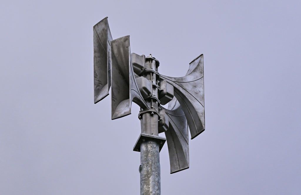 Eine Sirene steht in einer brandenburgischen Stadt.