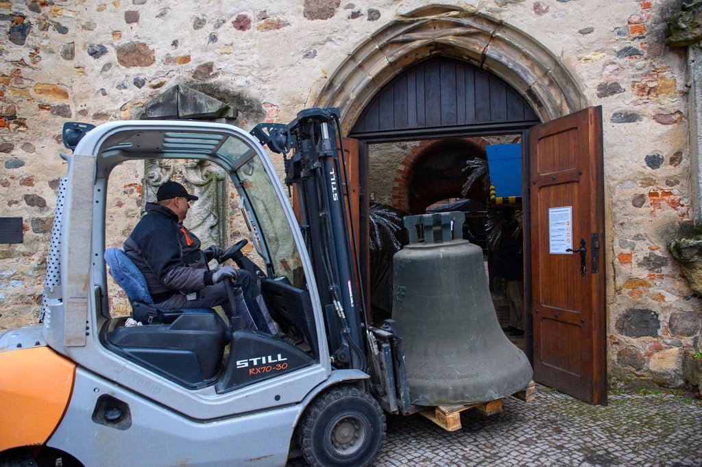 Ein Gabelstaplerfahrer manövriert eine Glocke durch das Enge Westportal der Bartholomäikirche.
