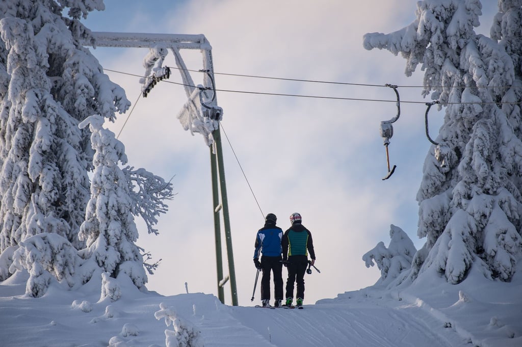Skifahrer lassen sich am Sonnenberg im Oberharz mit einem Schlepplift den Berg hochziehen.
