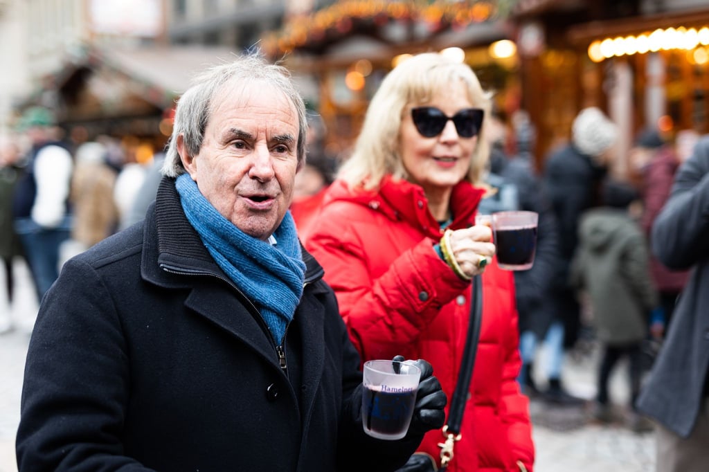 Chris de Burgh (l) und seine Frau Diane Davison trinken auf dem Weihnachtsmarkt in Hameln Glühwein.