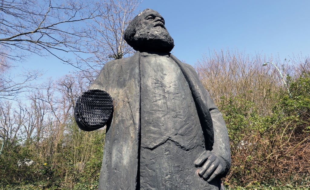 Das Denkmal des Philosophen Karl Marx steht ohne rechten unterarm an seinem Platz in einem Park.