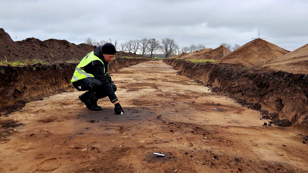 Christian Feddern zeigt auf Bodenverfärbungen, die auf Siedlungsreste hindeuten könnten. Noch bis zum kommenden Jahr wird das Team des Archäologen im Trassenverlauf der künftigen A 14 in der Niederen Börde Untersuchungen durchführen.