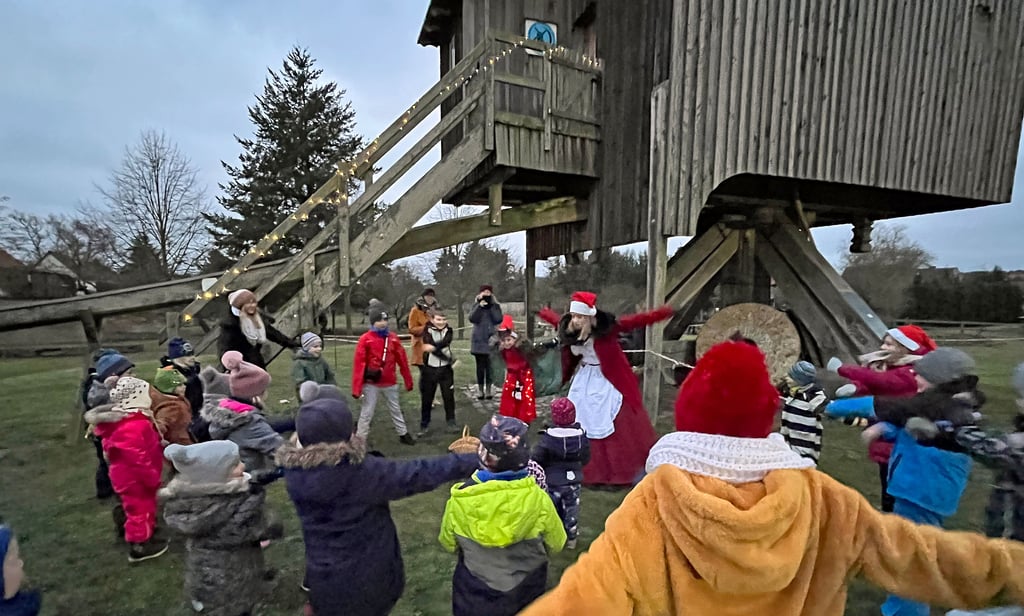 Die Weihnachtsfrau macht mit den Kindern an der Mühle in Grieben lustige Yogaübungen: "Der Schleifenwichtel" heißt die Figur, bei der beide Arme weit auseinander gerissen werden.
