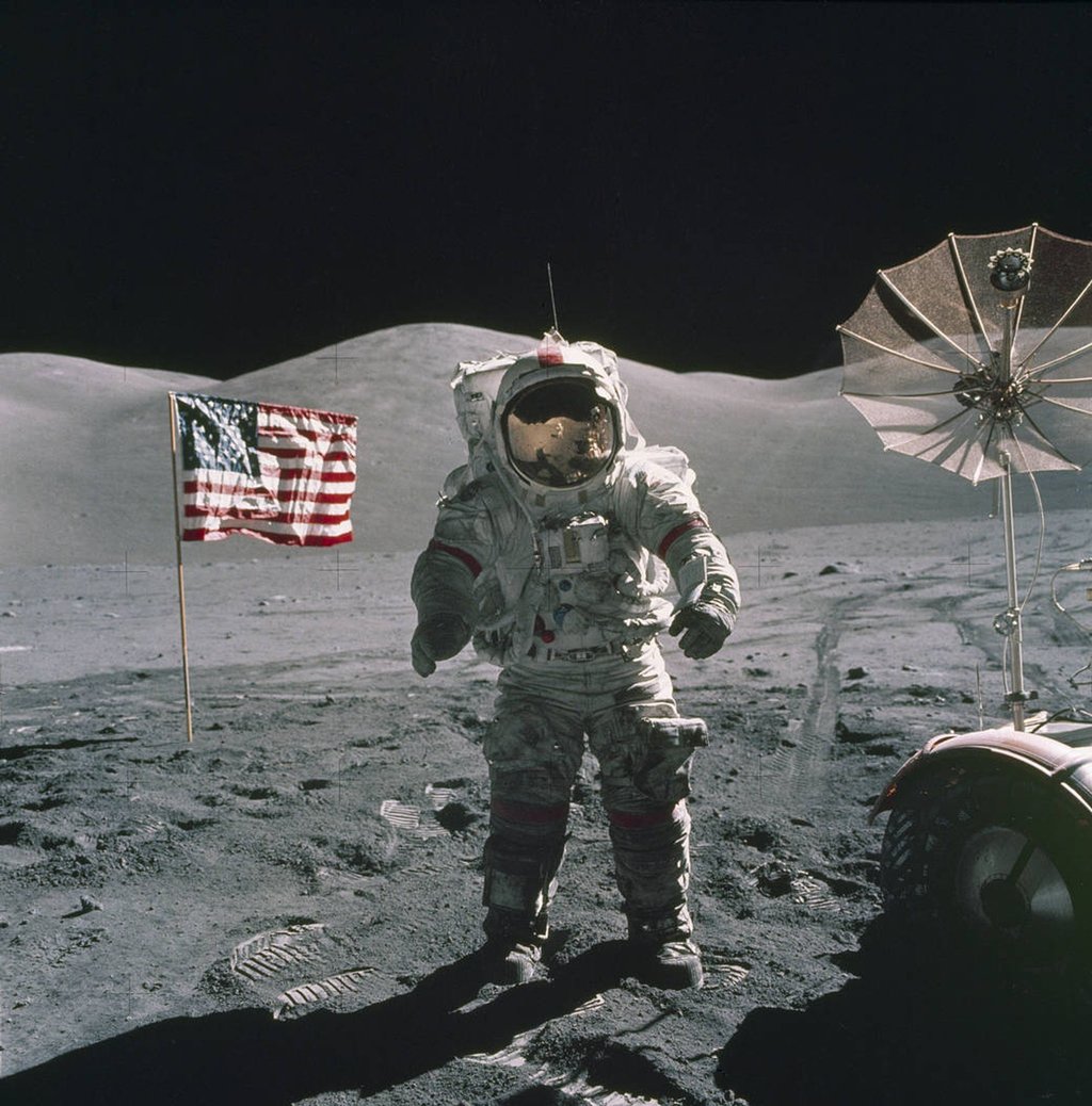 Der US-Astronaut Eugene Cernan steht auf dem Mond (1972), im Hintergrund die US-Fahne.