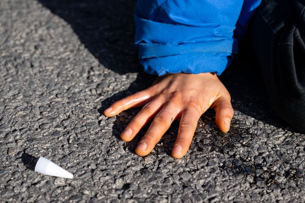 Ein Klimaaktivist hat sich auf einer Straße festgeklebt.