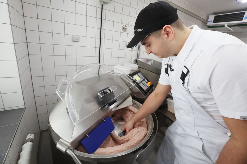 Joe Trommer bearbeitet Fleisch in einem Kutter.