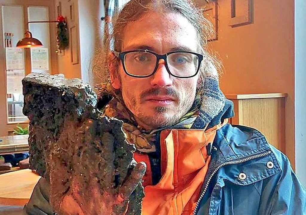 Die halbe Straße an der Hand: Weil sich der Klimaaktivist mit einem für die Polizei unlösbaren Spezialkleber am Asphalt fixiert hatte, musste der Straßenbelag aufgebrochen werden.