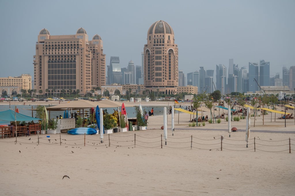 Strandleben in Doha: Baden im persischen Golf mit Blick auf die Skyline.