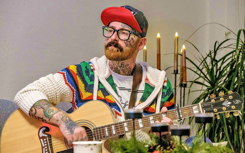 Der Zschornewitzer Martin Hofmann mit seiner Gitarre zu Hause auf dem Sofa.