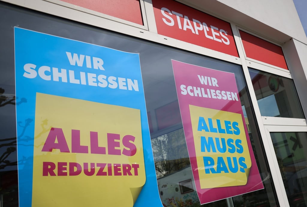 „Wir schliessen - Alles Reduziert“ und „Alles muss Raus“ steht auf Plakaten im Schaufenster eines Staples-Büromarkts.