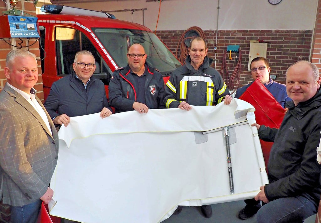 Fürs Foto wurde solch ein mobiler Rauchverschluss einmal ausgepackt. Das nicht brennbare Tuch wird mit Metallrahmen und dazwischen einer Spreizstange zum Beispiel in Türöffnungen geklemmt. Dadurch werden Brandgase am Ausbreiten gehindert. Bei der Übergabe im Gerätehaus der Osterwiecker Ortsfeuerwehr von links: die ÖSA-Vertreter Ralf Döppelheuer und Frank Meyer, Stadtwehrleiter Olaf Chrost, Ortswehrleiter und Zugführer Marco Krenge, Andreas Kröpper, zuständig für den Brandschutz in der Stadtverwaltung, und Bürgermeister Dirk Heinemann.